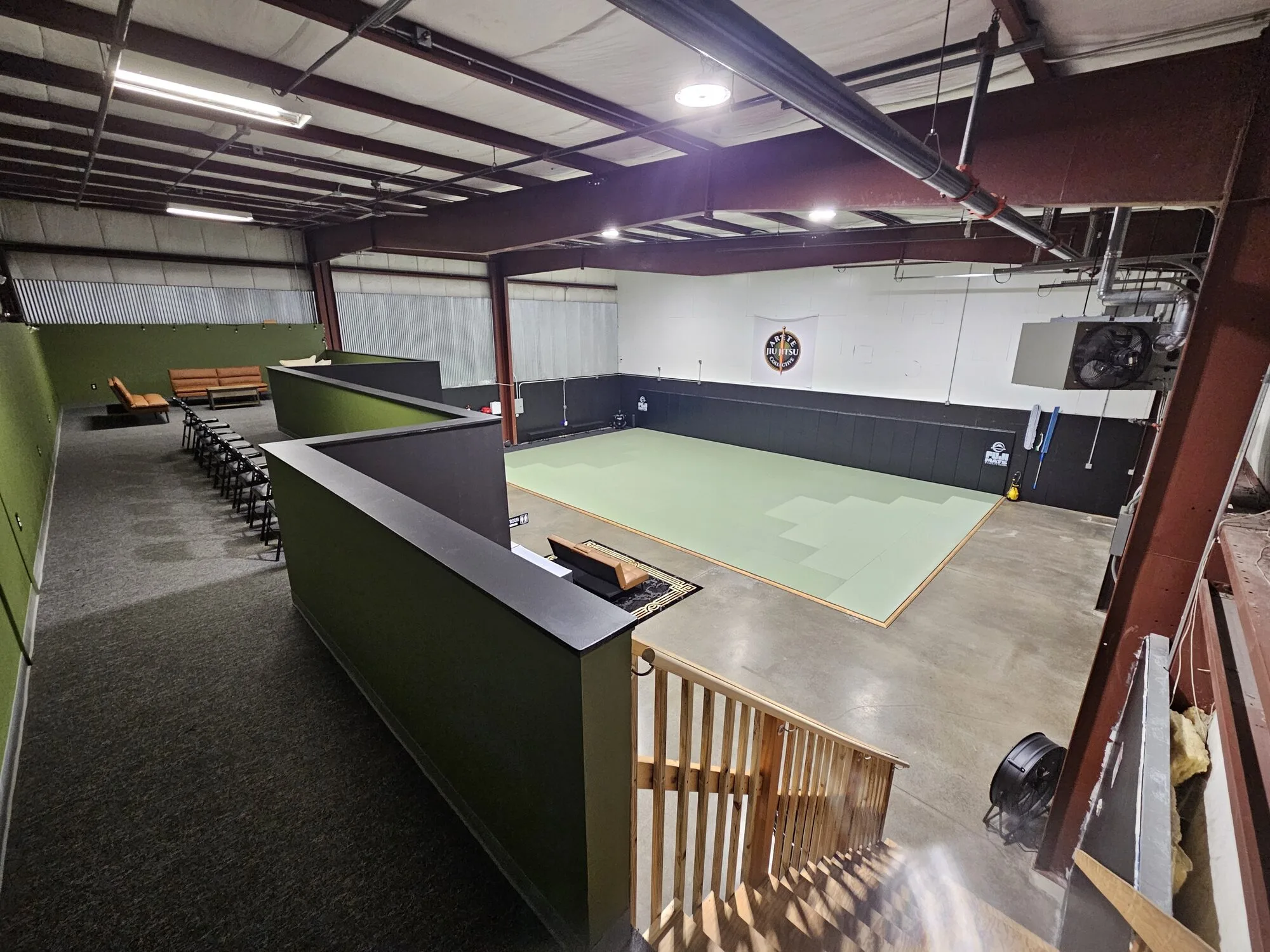 Arete academy from the top of the stairs — elevated view over the mat and mezzanine